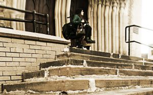 Woman in powerchair looks out from the top of a series of stone stairs.