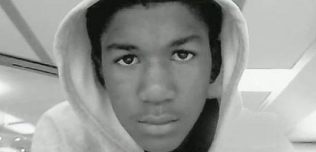 A close up of a young black boy's face, wearing a hoodie.